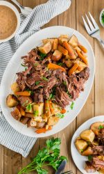 Gluten-free Pot Roast on a platter with a bowl of gravy