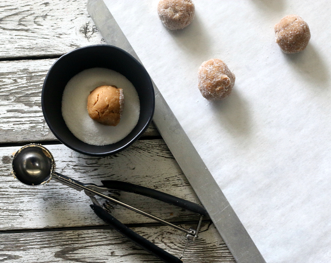 Rolling gluten-free peanut butter cookies in sugar