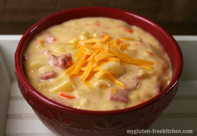 Photo shows a bowl of ham and cheddar chowder topped with shredded cheese