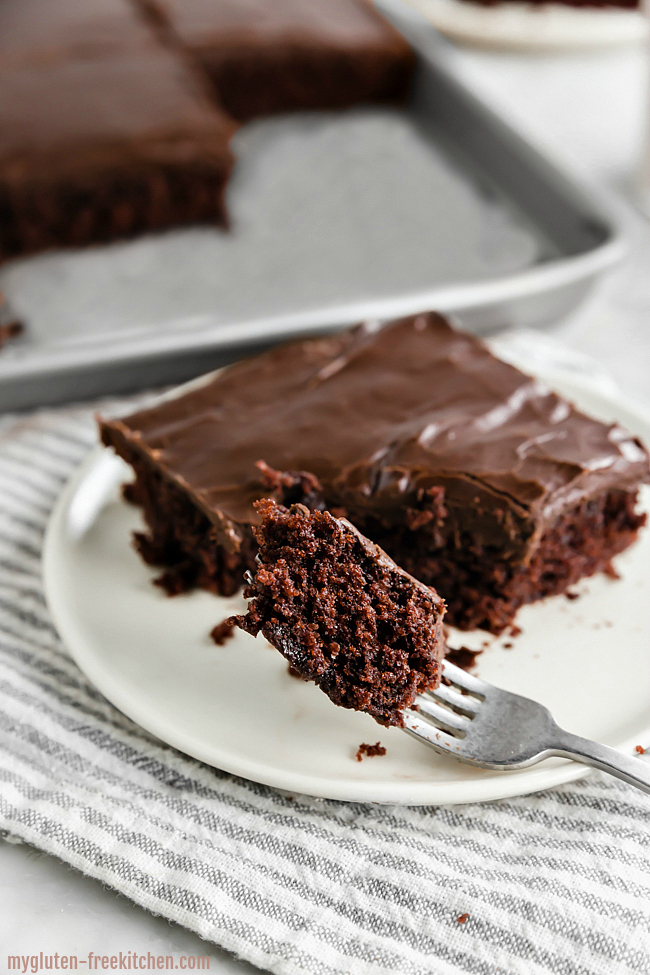 Slice of gluten-free chocolate cake with a bite on fork