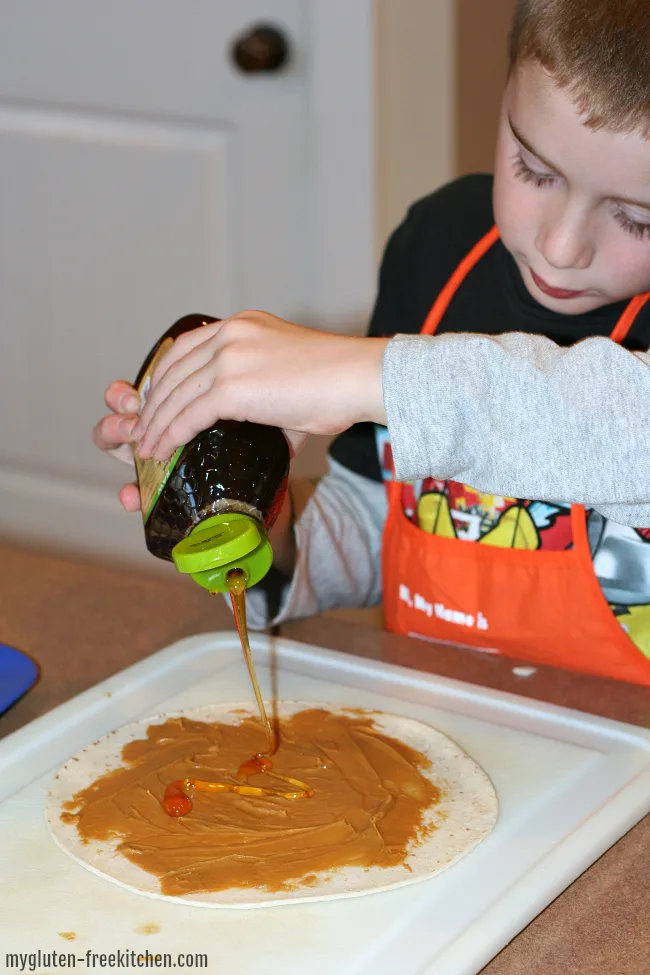 Making peanut butter and honey tortilla roll ups