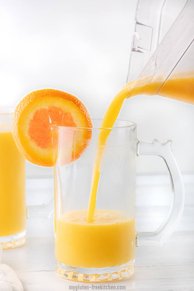 Pouring homemade orange julius from blender into glass