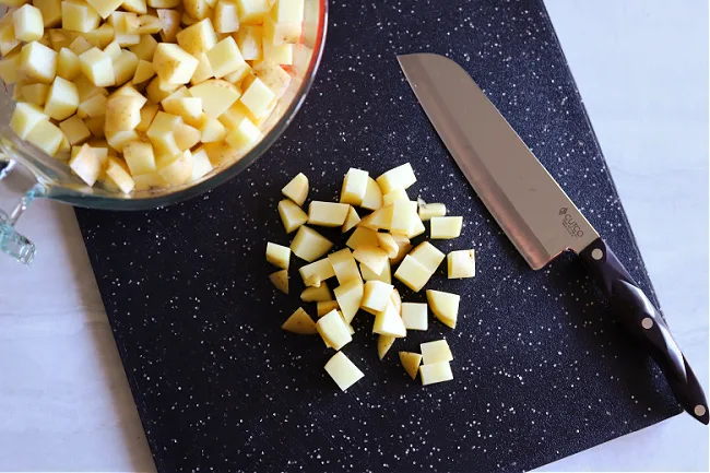 cutting potatoes on cutting board with sharp knife