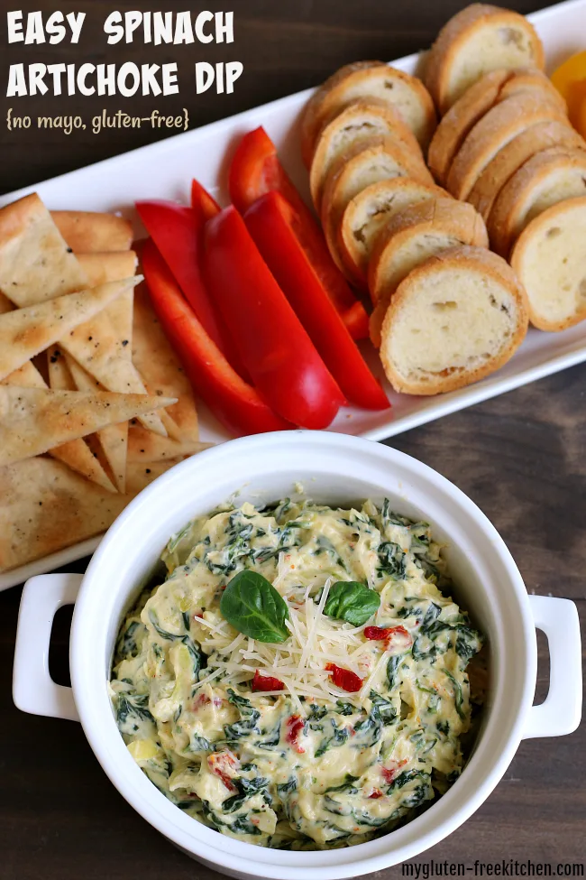 bowl of spinach artichoke dip alongside sliced bell peppers.