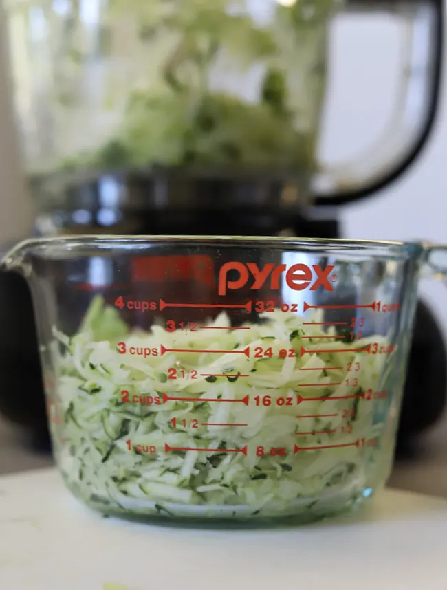measuring cup with 3 cups shredded zucchini for gluten-free zucchini bread