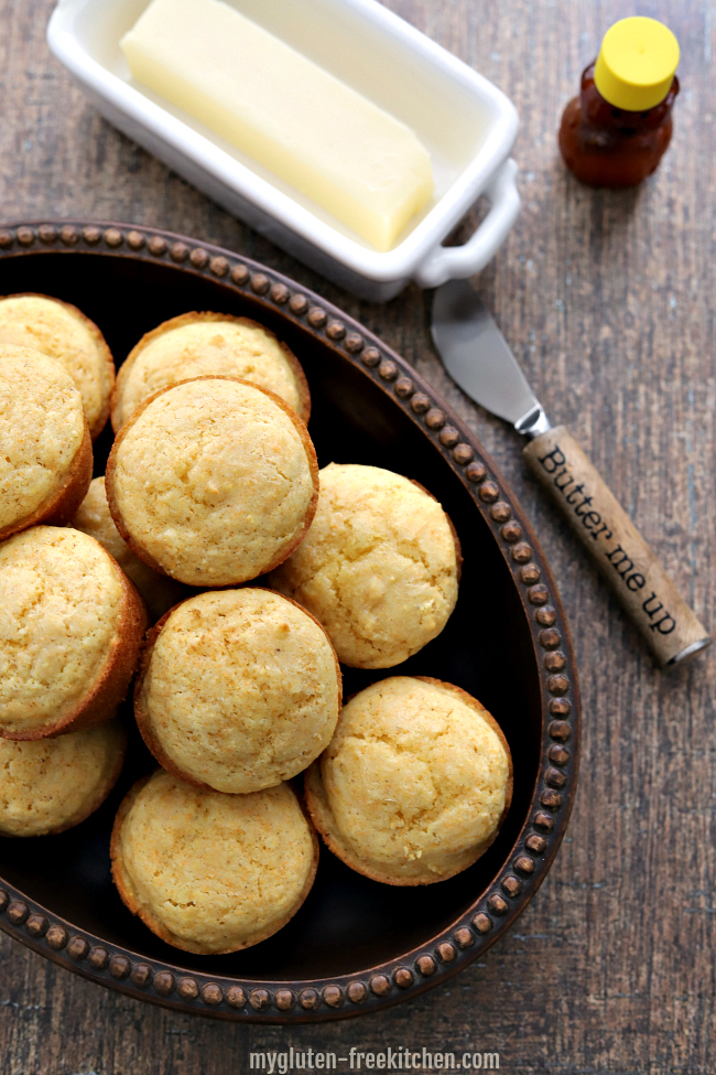 Gluten-free Corn Muffins in bowl with knife and butter