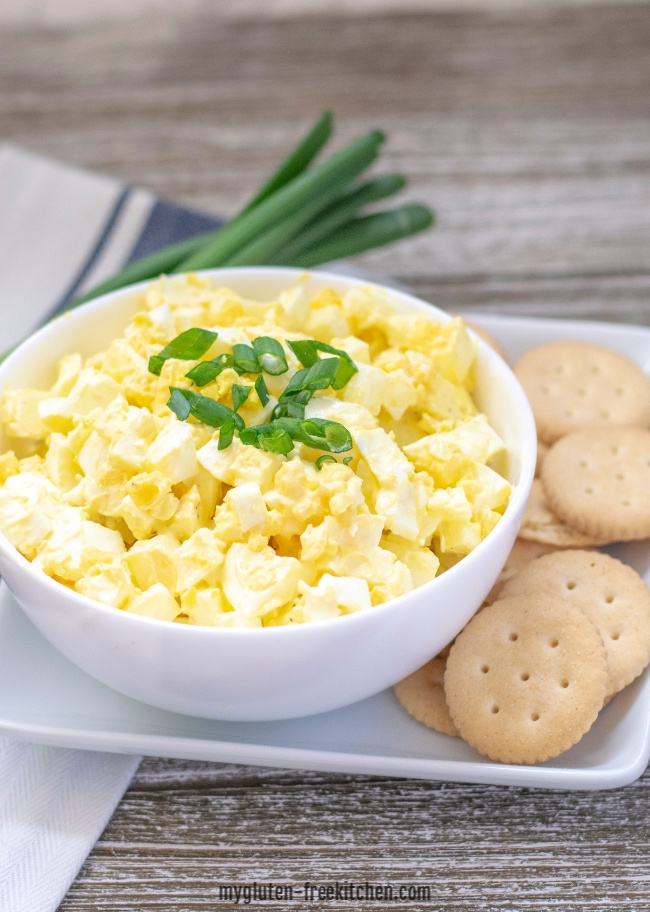 Bowl of egg salad with crackers next to it