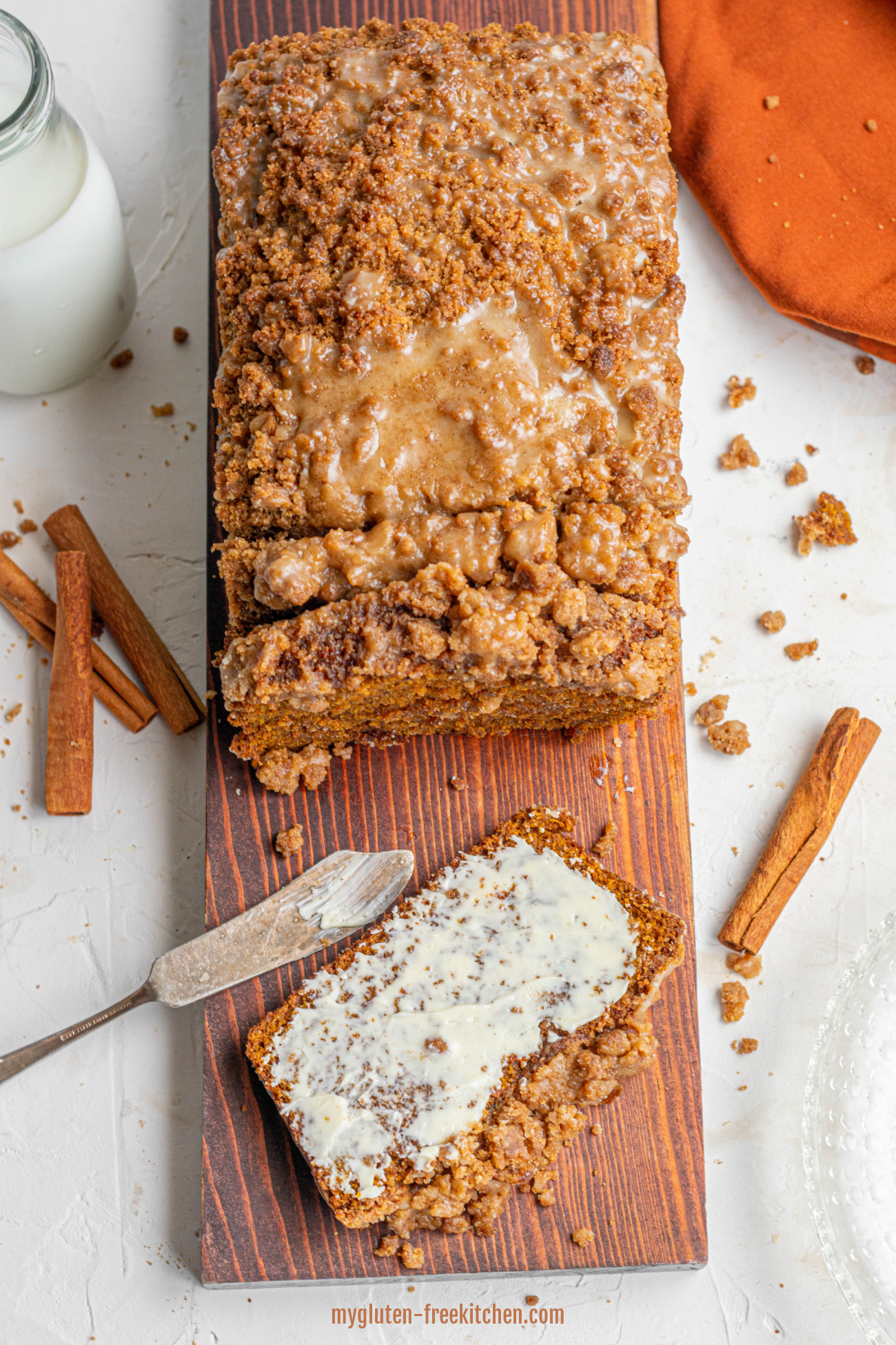 Gluten-free Pumpkin Bread on wood board with one slice with butter and a butter knife