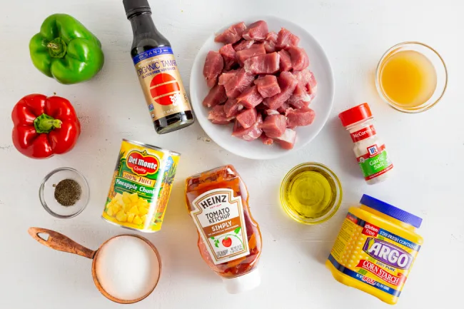 bowl of pork chunks, various other ingredients for making sweet and sour pork