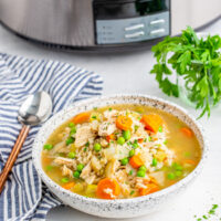 Gluten-free Slow Cooker Turkey and Rice Soup in a bowl with crockpot in background