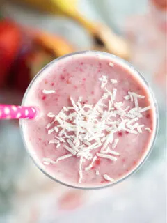 Coconut Strawberry Banana Smoothie in a glass with coconut on top