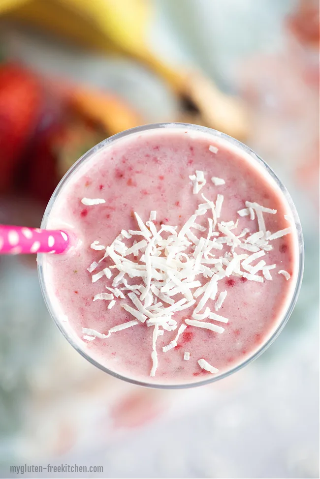 Coconut Strawberry Banana Smoothie in a glass with coconut on top