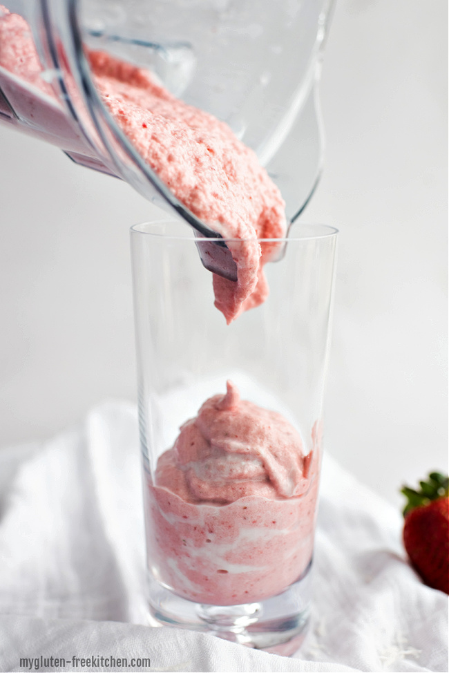 Pouring strawberry banana coconut smoothie into a glass