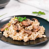 black plate with gluten-free risotto with mushrooms.