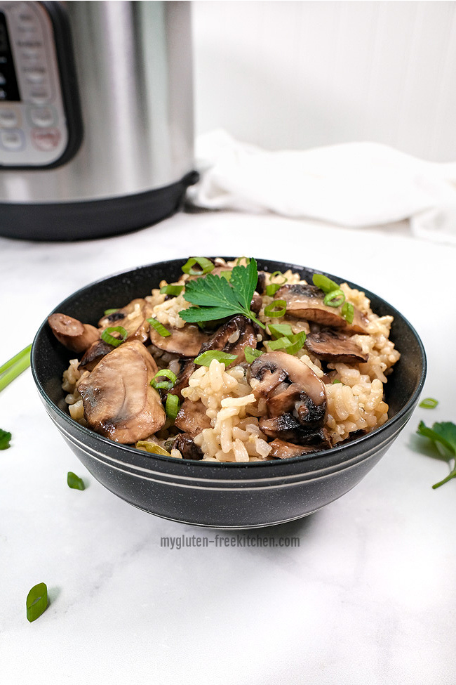 black bowl with mushroom risotto with Instant Pot in background